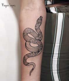 a black and white snake tattoo on the arm