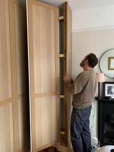 a man standing in front of a wooden closet