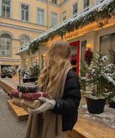 a woman standing in front of a building with snow on the ground