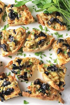 an assortment of appetizers on a white plate with parsley sprigs