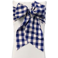 a blue and white checkered pillow with a large bow on the front of it