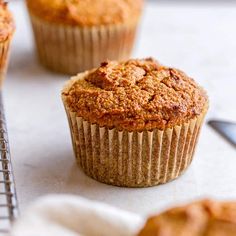 several muffins sitting on top of a counter next to a baking rack and spatula