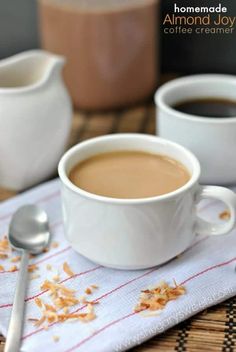 two cups of coffee on a table with spoons