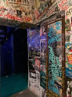 an alleyway with graffiti on the walls and door to another room that has been painted blue