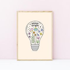 a light bulb with flowers in it and the words bloom bright written inside is shown