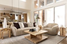 a living room filled with furniture and large windows