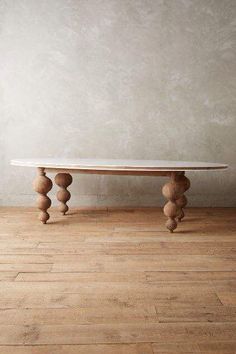 a white table sitting on top of a hard wood floor next to a gray wall