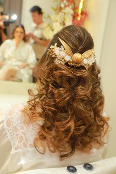 the back of a woman's head with long hair and flowers in her hair