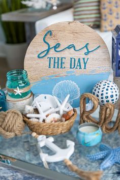 there is a sign that says seas the day next to shells and other items on a glass table