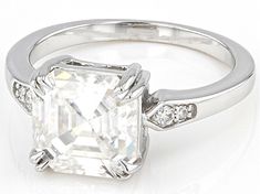 Moissanite Fire® 3.98ctw diamond equivalent weight square octagonal asscher cut and round brilliant cut, Platineve® ring. Measures approximately 5/16" L x 1/16" W and is not sizeable. Actual moissanite weight is 3.47ctw. . Gia Certified Asscher Cut Diamond Ring, Gia Certified Asscher Cut Diamond White Diamond Ring, Gia Certified Diamond White Asscher Cut Ring, Gia Certified Asscher Cut Dazzling Wedding Ring, Dazzling Asscher Cut Diamond White Diamond Ring, Dazzling Asscher Cut Diamond White Ring, Dazzling Octagon Diamond Ring With Brilliant Cut, Dazzling Octagon Diamond Ring For Formal Occasions, Dazzling Formal Diamond Ring With Octagon Shape