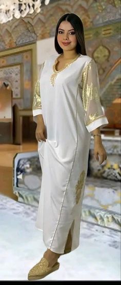 This top quality garndoura, made of silk crepe, zwak lmaalem and Tlija sleeves. This caftan is ideal for family occasions such as family celebrations, the month of Ramadan, Aid, or weddings. Several sizes available, it is possible to have it in a Matchi-Matchi version: mother/daughter. It is also possible to personalize your caftan according to your taste, contact us for more information. Top quality caftan, in silk crepe, with zwak lmaalem. This caftan is ideal for family occasions such as family celebrations, the month of Ramadan, aid, or weddings. Several sizes available, it is possible to have it in Matchi-Matchi version: mom/daughter. It is also possible to customize your caftan according to your taste, contact us for more information Elegant White V-neck Thobe, Festive White Kaftan For Eid, White V-neck Kaftan For Festive Occasions, Elegant White Long Sleeve Agbada, Gold Long Sleeve Kaftan For Eid, Elegant Agbada For Traditional Ceremonies And Festivals, Elegant V-neck Kaftan For Festivals, Elegant Kaftan For Eid Celebration, Elegant White V-neck Abaya