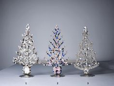 three crystal christmas trees with blue and white crystals on them, all in different sizes