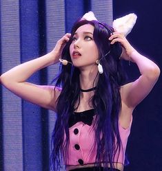 a woman with long black hair wearing a pink top