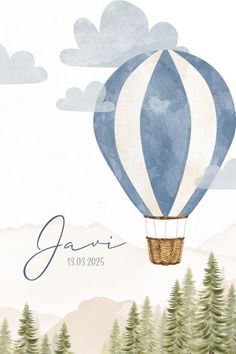 a blue and white hot air balloon in the sky with trees on it's side