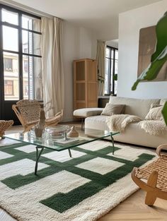 a living room filled with furniture and a glass table on top of a white rug