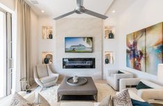 a living room filled with furniture and a flat screen tv mounted to the wall over a fire place