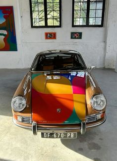 a colorful car parked in a garage next to two windows