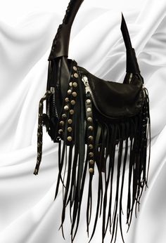 Black Shoulder Bag. Small Totte Rock Fashion Bag. Black Top Leather Handle Bag with fringes. Timeless Rock Look forever Black Leather Bag with silver metallic rivets-fringes- 2 zipper on the bottom of the Bag..in order to make it..smaller or bigger according to the items. 2-pockets with zippers in front of the Bag and fringes.--for cellphone-keys etc. The strap is-round-soft to touch and nicely knitet on the top visible part. of the handle. 2 Long black fringes with silver rivets decorate the 5 Black Punk Style Satchel Shoulder Bag, Gothic Party Bag With Zipper Closure, Black Punk Satchel Shoulder Bag, Black Gothic Shoulder Bag For Concert, Gothic Black Bags With Metal Hardware, Gothic Black Shoulder Bag With Adjustable Strap, Gothic Bag With Adjustable Strap For Concerts, Black Bags With Zipper Closure For Concerts, Black Punk Bag With Adjustable Strap