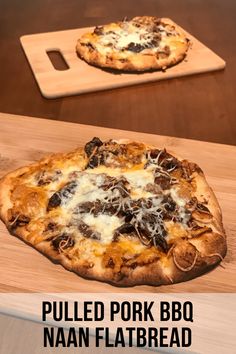 two pizzas sitting on top of a wooden cutting board