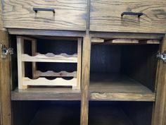 a wooden cabinet with two open shelves and one closed shelf on the bottom, holding wine bottles