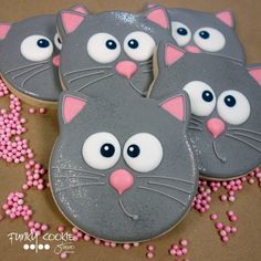 three decorated cookies with cat faces on them