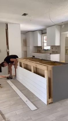 a man working on an unfinished kitchen countertop in a new home under construction,