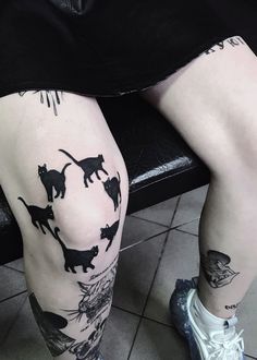 a person with tattoos on their legs sitting in a chair