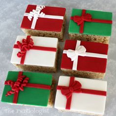 four decorated square pieces of cake with bows and ribbons on them sitting on a table