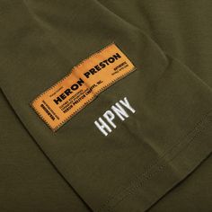 a label on the back of a khaki green jacket that says hippy