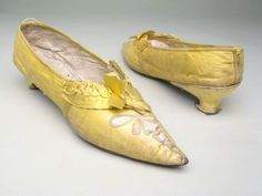 an old pair of gold shoes on a white surface