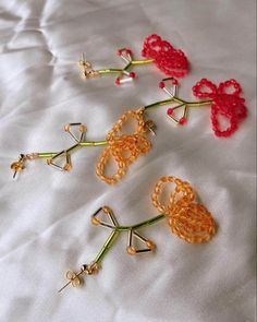 three crocheted flowers sitting on top of a white bed next to each other