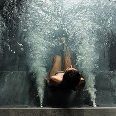 a person laying down in the water with their feet on the edge of an aquarium