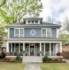 a blue house with white trim on the front porch and steps leading up to it