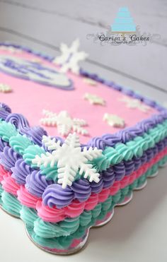 a cake that is decorated with icing and snowflakes