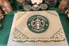 there is a birthday cake with the starbucks logo on it and cupcakes around it