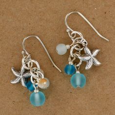 the earrings are made from silver and glass beads with seashells, starfish, and seaweed charms