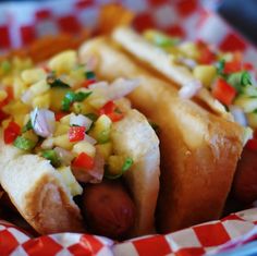 two hot dogs with toppings in a basket