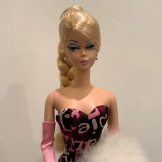 a barbie doll wearing a pink and black dress with white fur on the bottom half