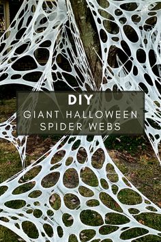 a white spider web hanging from a tree with the words diy giant halloween spider webs