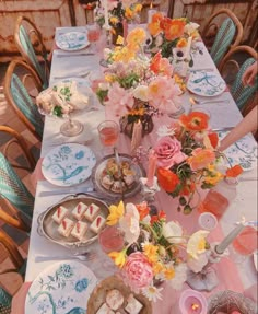 a long table with plates and flowers on it