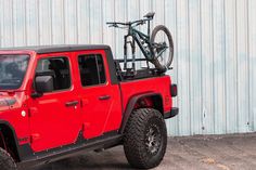 a red jeep with a bike on the back