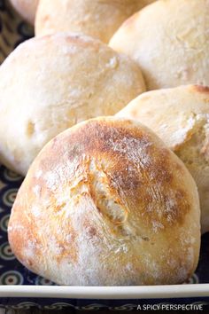 some bread rolls are on a blue and white plate