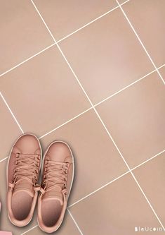 a pair of pink sneakers sitting on top of a tiled floor