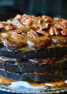 a chocolate cake with caramel drizzled on top and pecans in the middle