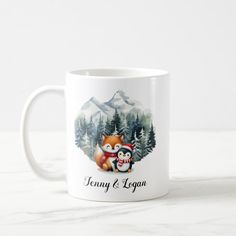 a white coffee mug with an image of a fox and penguin on it, surrounded by pine trees