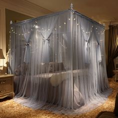 a canopy bed covered in white netting with fairy lights