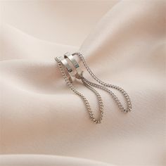 A silver-plated ear cuff featuring a dangling layered chain. 0.43" W x 1.96" L Silver-plated copper Layered Chain, Layered Chains, Ear Cuff, Silver Plate, Silver Plated, Silver Tone, Copper, Plating, Cuff