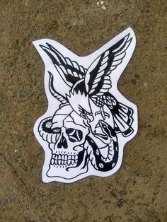 a sticker with a skull and two birds on it