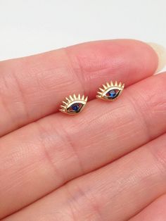 925 Sterling Silver Tiny Blue Sapphire Evil Eye Stud Earrings   - Metal: 925 Sterling Silver (Finish: Gold Plated) - Stone: Lab-Created/Synthetic Blue Gemstone/Sapphire - Shape: Evil Eye - Dimension: 6.5mm(0.26 in) x 3.8mm, Thickness 1.5mm - Closure: Post at Above Center, Push Back - Color: Gold Blue Round Evil Eye Earrings, Blue Sterling Silver Evil Eye Earrings, Studs Gold, Evil Eye Earrings, Eye Earrings, Sapphire Earrings, Blue Gemstones, Evil Eye, Blue Sapphire