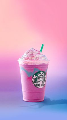 a pink starbucks drink sitting on top of a blue and pink table next to a pink wall